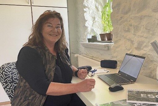 Mona Sloth fra Kongsvad GTM, - et medlem af Mariagerfjord Erhverv, sidder på sit kontor og smiler til kameraet.