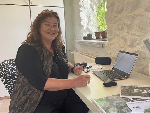 Mona Sloth fra Kongsvad GTM, - et medlem af Mariagerfjord Erhverv, sidder på sit kontor og smiler til kameraet.