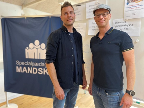 Morten Houmann Larsen og Nicolai Munk Jacobsen, Ejere, Socialpædagogisk Mandskab - et medlem af Mariagerfjord Erhverv, poserer smilende for kameraet.